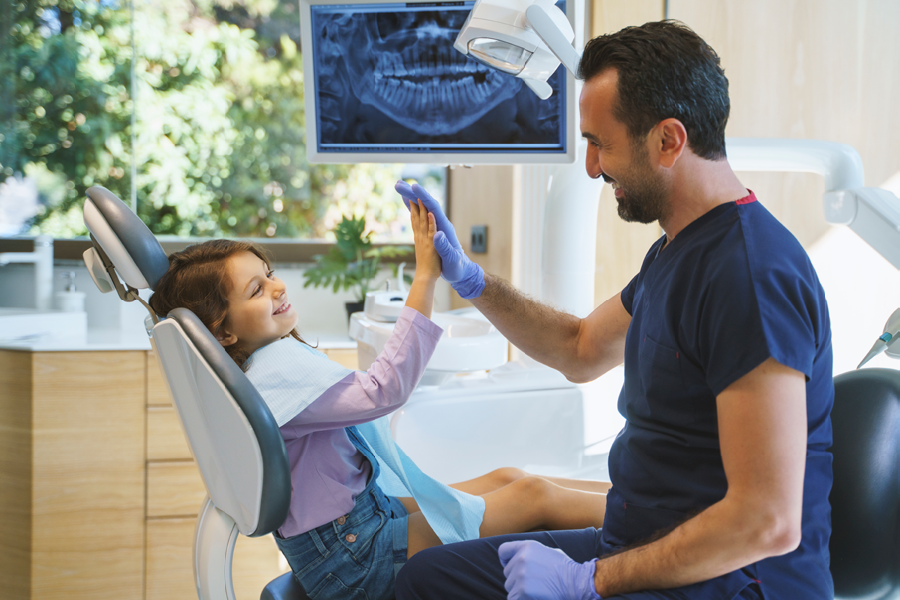 Dentist talking to a child patient in the dental office.