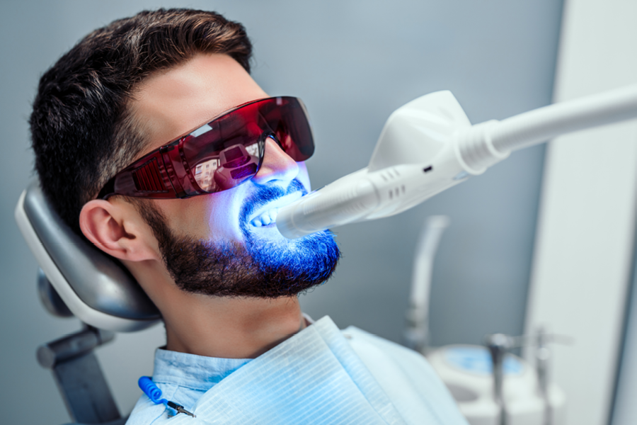 Person at the dentist receiving a tooth whitening treatment. 