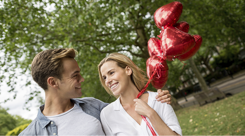 Couple walking with heart balloons