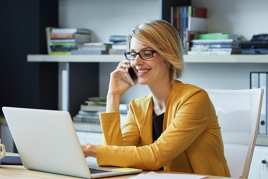  Woman working in an office setting with glasses on.