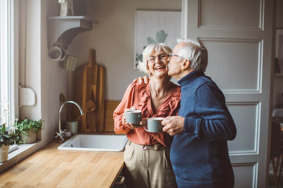 Older couple smiling and drinking their coffee.