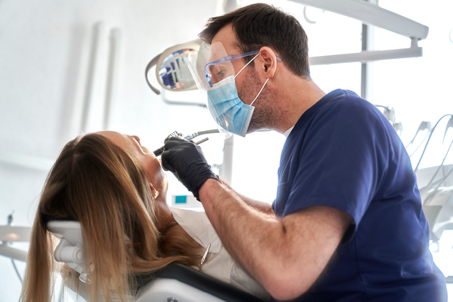 Dental professional performing dental work on a patient.