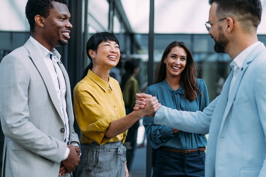 Group of coworkers talking and smiling in the office.