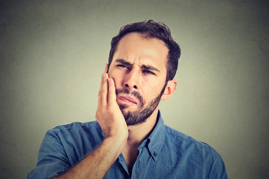 Man holding his jaw 