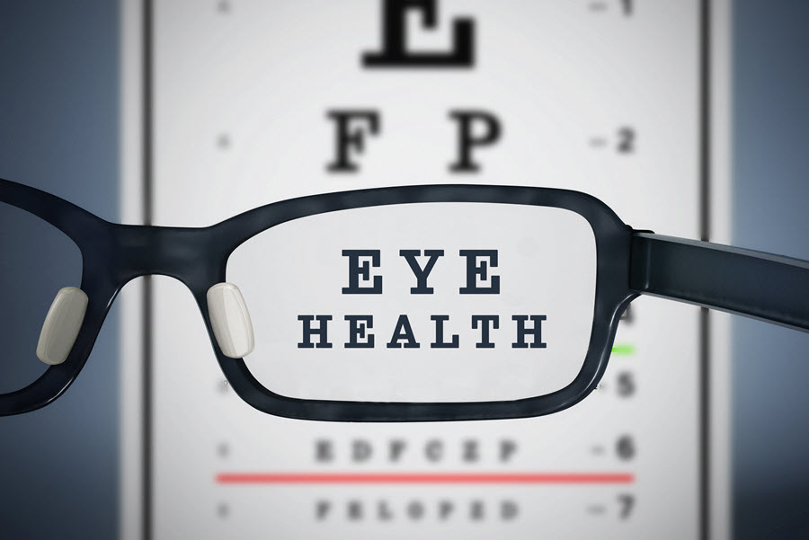 Glasses in front of a letter reading chart showing the words "eye health" 