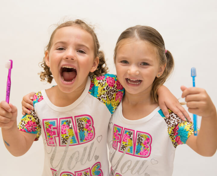 two children brushing their teeth