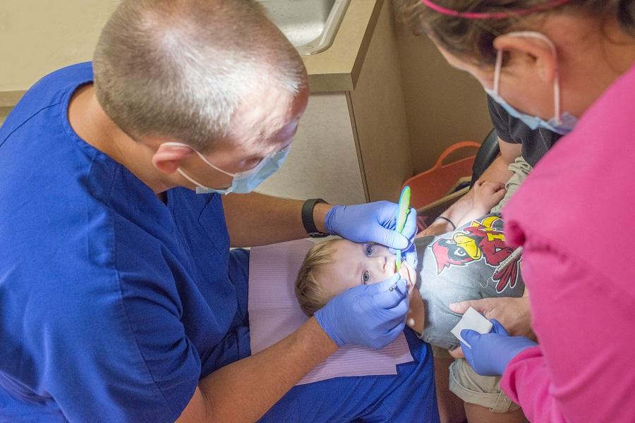 Dentist looking at child patient