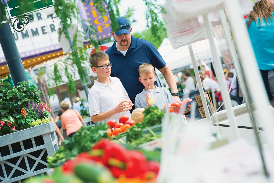 Father and sons looking at fruit and veggies.