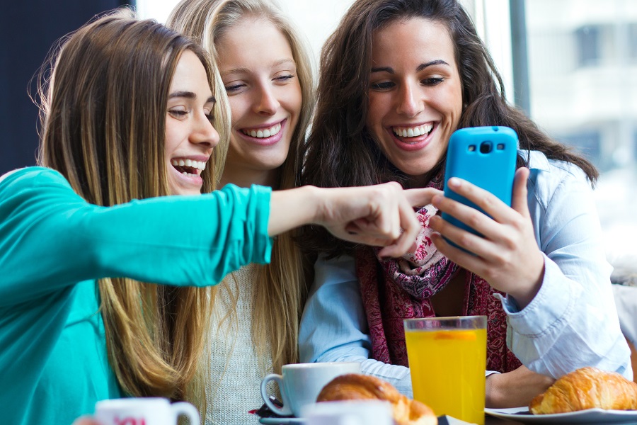 3 girls being entertained by a phone