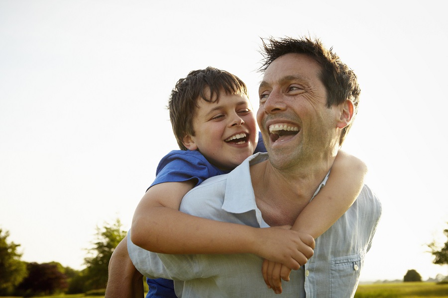 Father holding his son on his back 