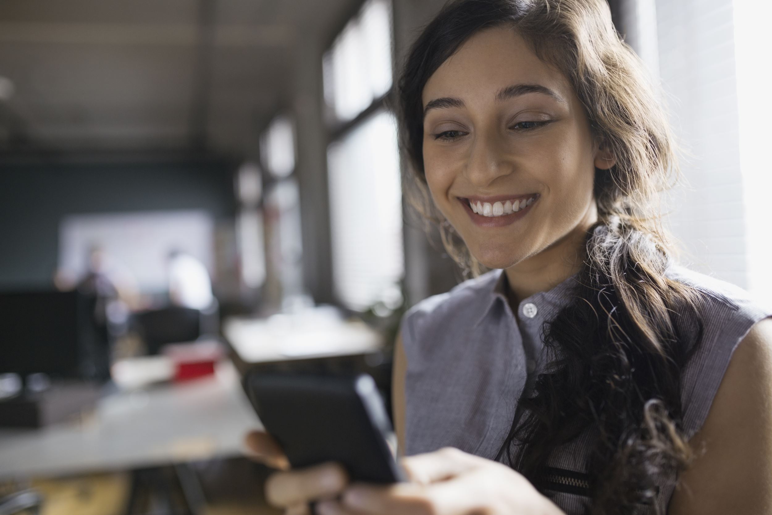 Gen z female smiling while looking at her phone