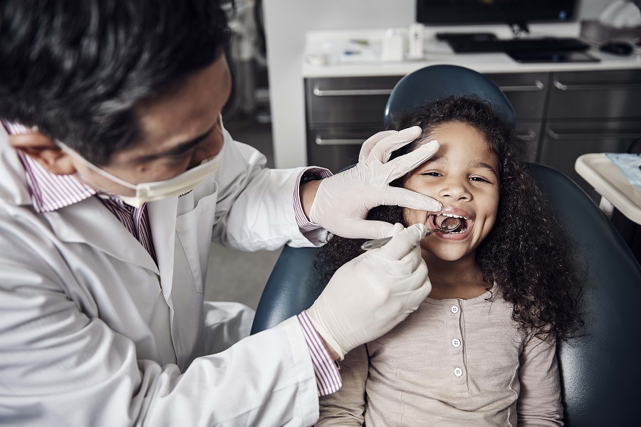 Dentist looking inside a girls mouth