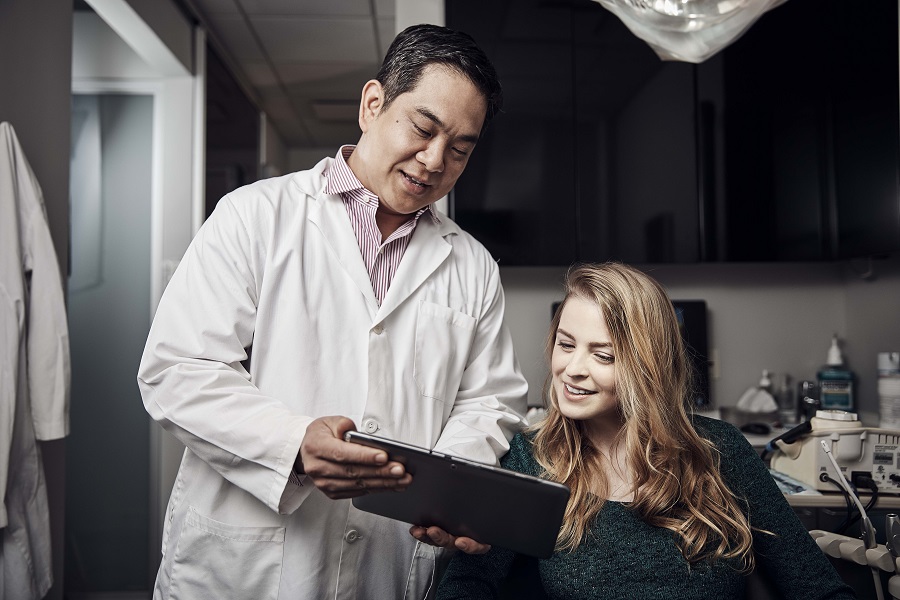 Dentist showing a patient an Ipad with info