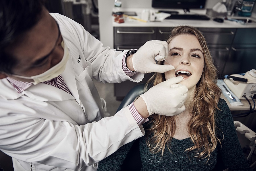 Dentist flawsing a patients teeth