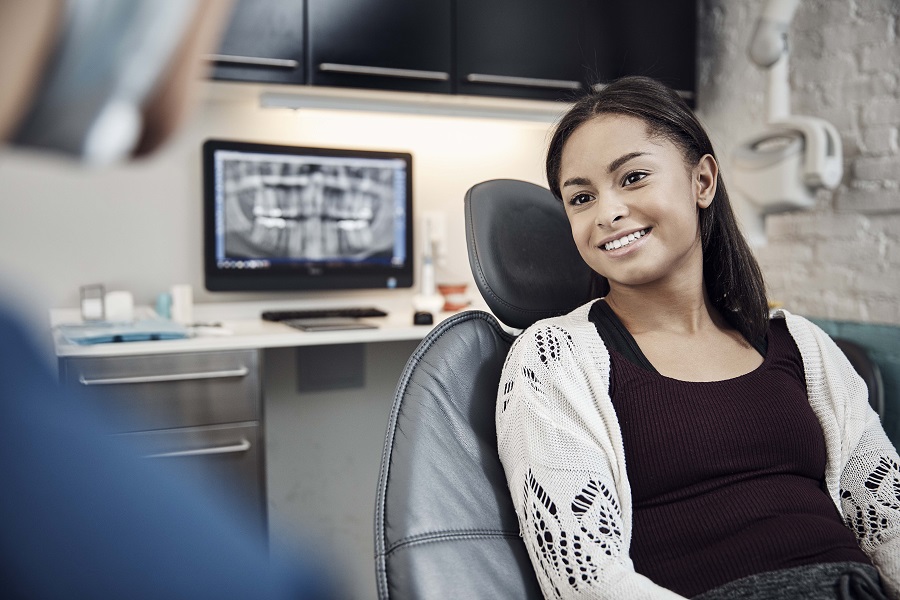 Younger Lady sititng in dentist chair