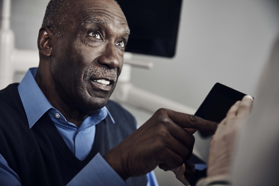 Older adult male talking to dentist