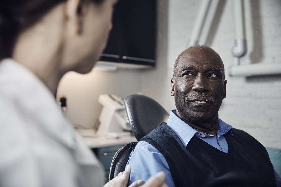 Dentist talking to a male patient