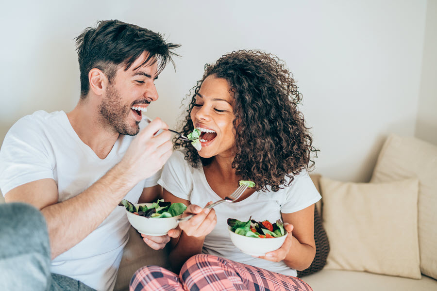 Man and woman eating salad
