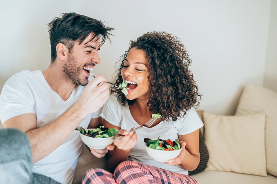 Man and woman eating salad