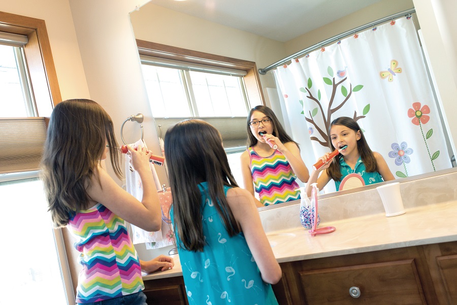 Sisters brushing teeth in bathroom