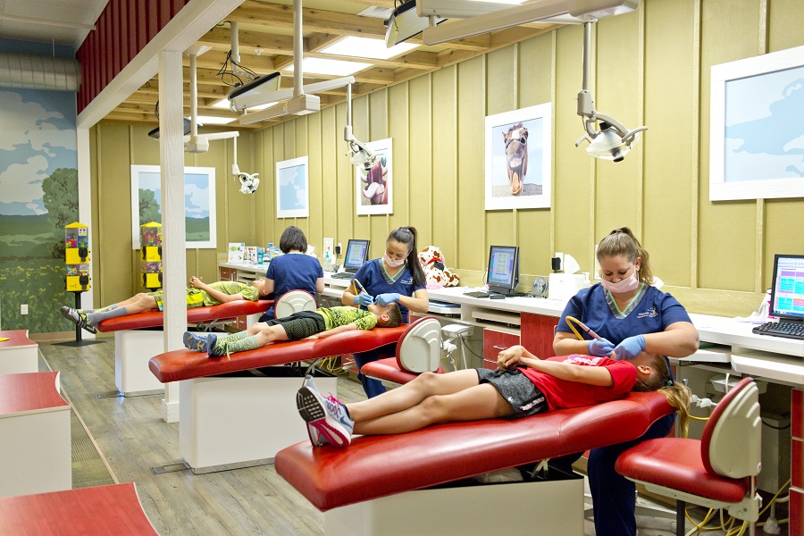 Room of dental chairs, patients and dentists