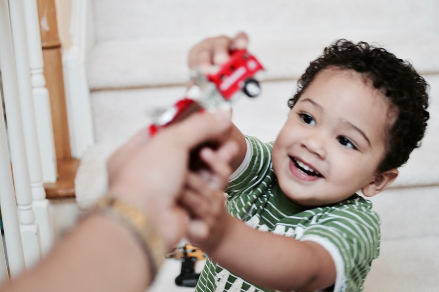 Little boy reaching for a toy