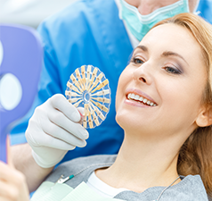 woman in dental chair looking at the shade of her teeth