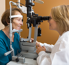 woman in dental chair looking at the shade of her teeth