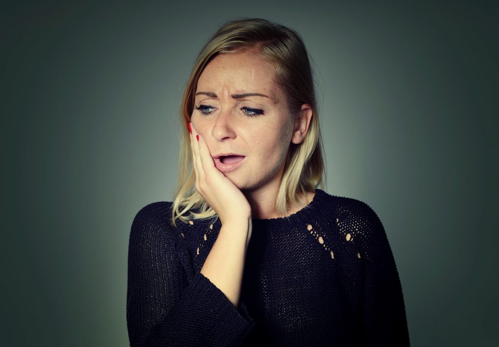 woman holding her jaw