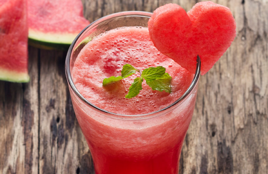 Water melon smoothie and fresh melon on wood background